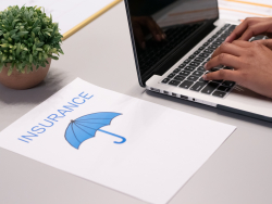 Paper with the word insurance and a picture of an umbrella