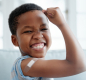 Boy with bandage on arm after vaccination flexing bicep
